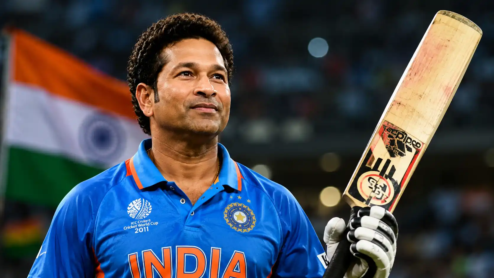 Sachin Tendulkar holding a cricket bat in Team India jersey with Indian flag in the background at a packed stadium