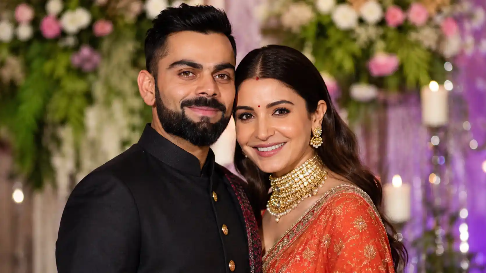 విరాట్ కోహ్లీ మరియు అనుష్క శర్మ సంప్రదాయ దుస్తుల్లో అందంగా పోజ్ ఇస్తున్న అందమైన జంట చిత్రం